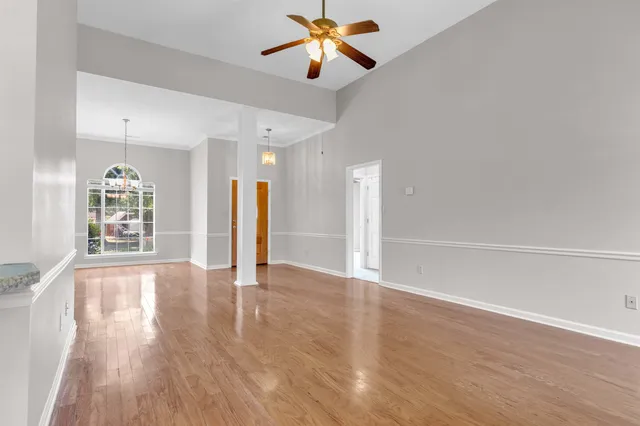 a view of an empty room with window and wooden floor
