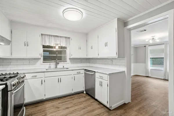 a kitchen with a sink cabinets and wooden floor