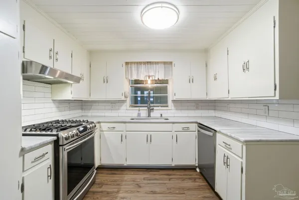 a kitchen with stainless steel appliances granite countertop a sink stove and cabinets