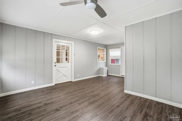 an empty room with wooden floor and windows