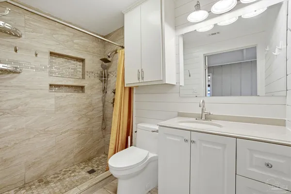 a bathroom with a sink a toilet and shower