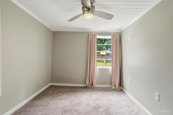 an empty room with a ceiling fan and window