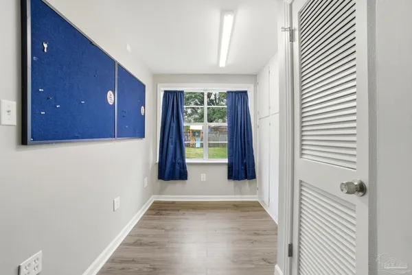 a view of a hallway with wooden floor and a window