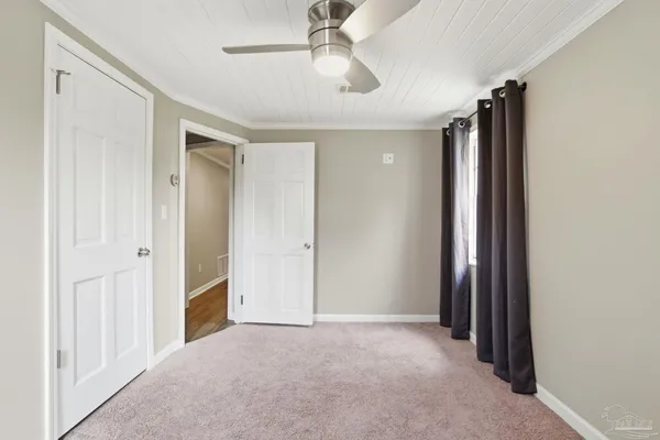 an empty room with closet and windows