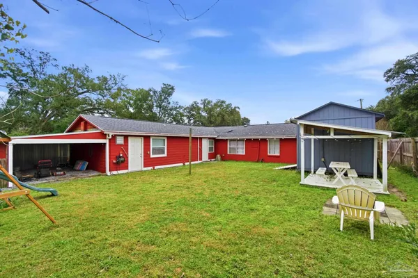 a view of a backyard with a slide and a wooden fence