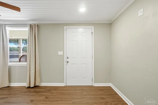 a view of an empty room with wooden floor