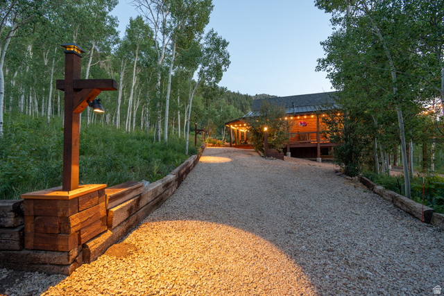 8737 Sage Run Road Kamas, UT 84036 - Photo 19 of 27 Gravel driveway bordered by timber retaining walls and illuminated by rustic post lights