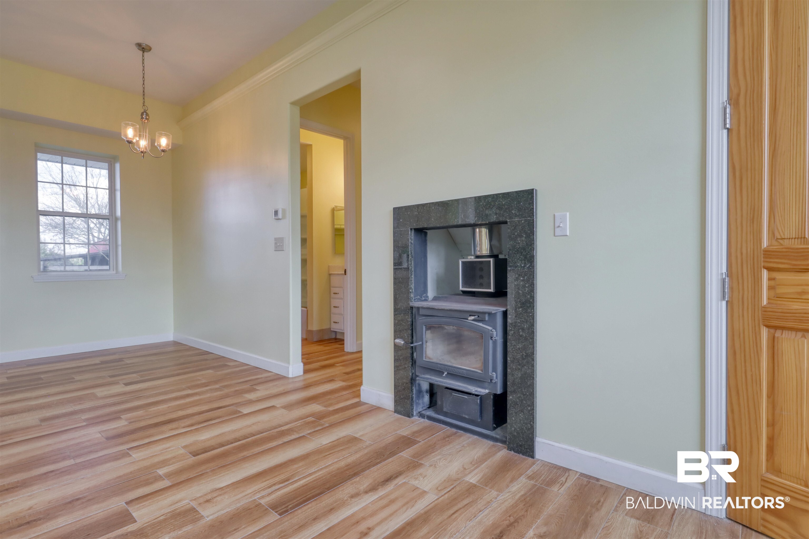28461 Gardner Road Elberta, AL 36530 - Photo 5 of 46 Unfurnished living room with light wood-style floors, hanging lights, and ornamental molding