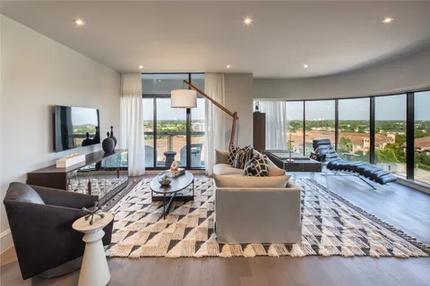 a living room with furniture large windows and a flat screen tv