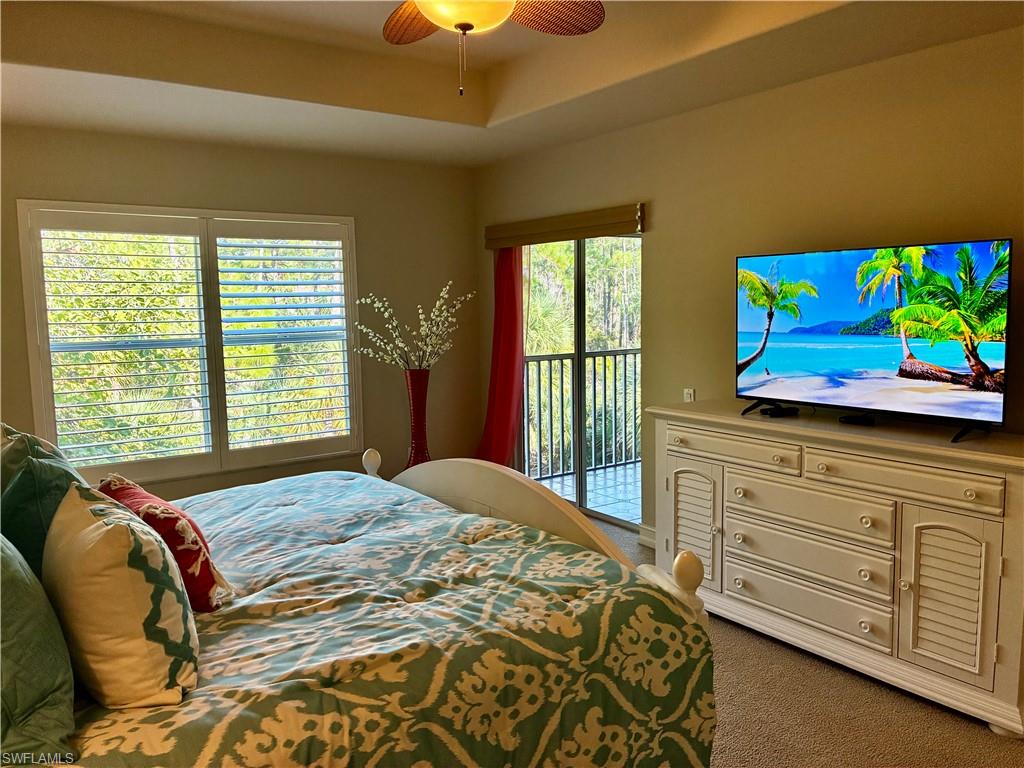 913 Carrick Bend Circle, Unit 202 Naples, FL 34110 - Photo 17 of 44 a bedroom with a bed and a flat tv screen on dresser