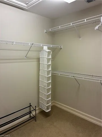 a view of walk in closet with empty racks