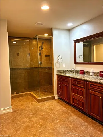 a bathroom with a granite countertop sink mirror and shower