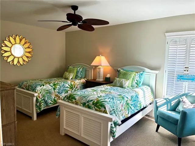 a bedroom with two beds and painting on the wall