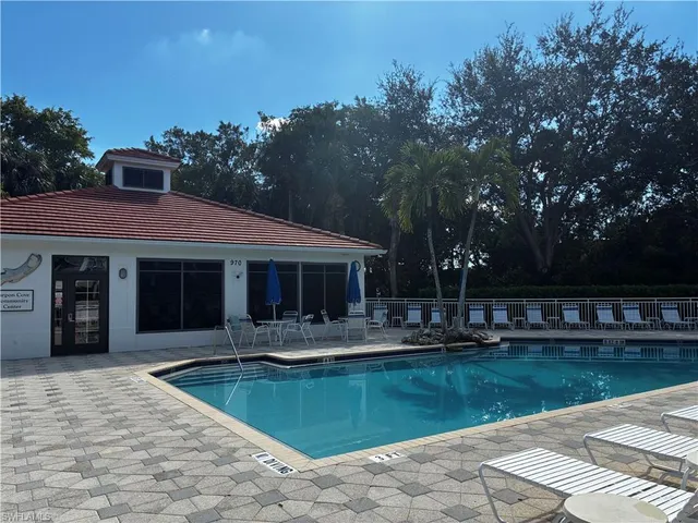 a front view of a house with swimming pool and a yard