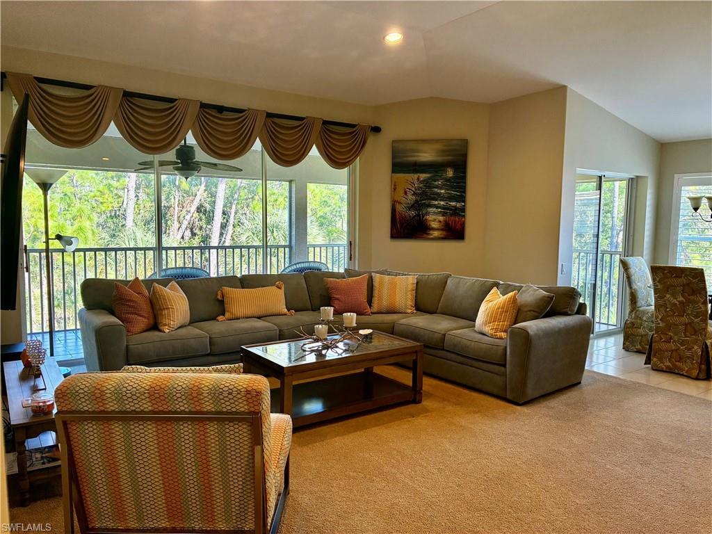 913 Carrick Bend Circle, Unit 202 Naples, FL 34110 - Photo 4 of 44 a living room with furniture a large window and a wooden floor