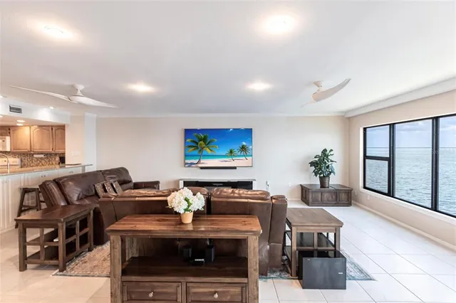 a living room with furniture a large window and a flat screen tv