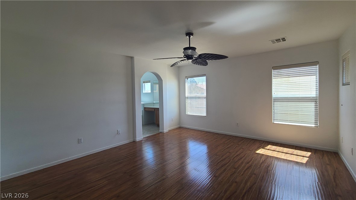 8944 Rutherford Grove Street Las Vegas, NV 89148 - Photo 15 of 35 Hardwood-style flooring and a ceiling fan create a comfortable atmosphere in this ample living space.