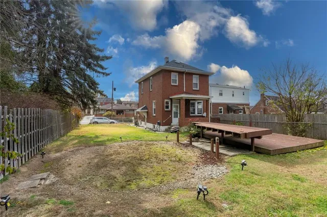 a view of a house with backyard and sitting area
