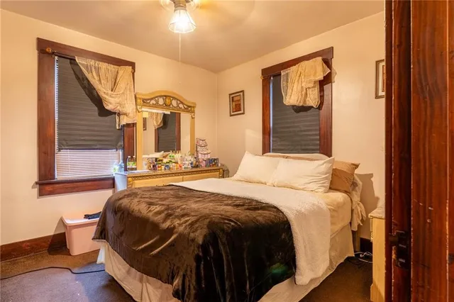 a bedroom with a bed and dresser with mirror