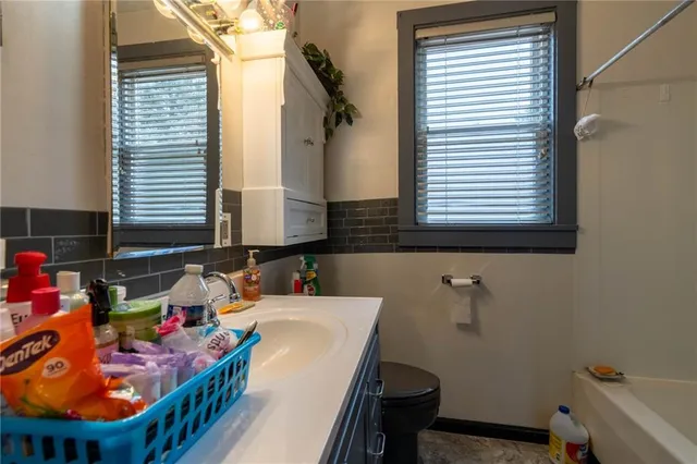 a bathroom with a tub sink and mirror