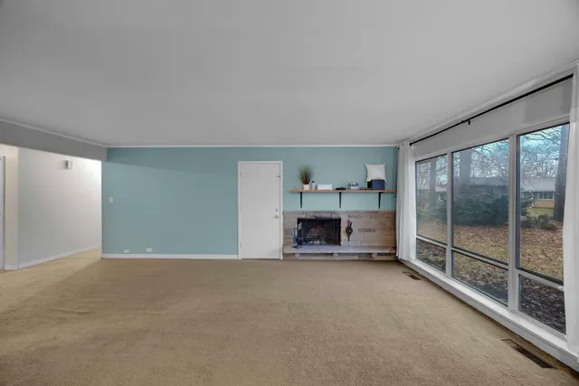 a view of empty room with fireplace and window