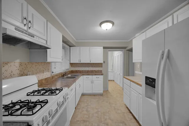 a kitchen with stainless steel appliances granite countertop a stove and a refrigerator