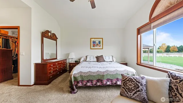 a bedroom with a bed and a dresser next to a window