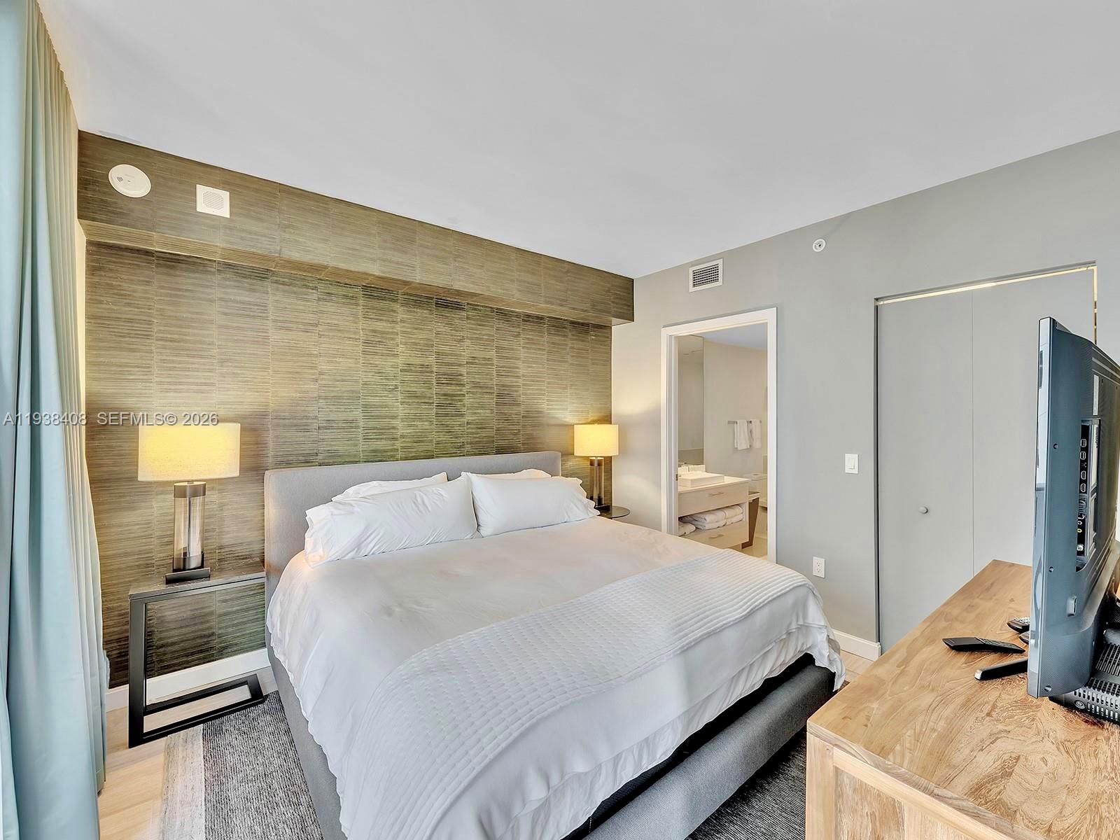 55 Southwest 9th Street, Unit 1808 Miami, FL 33130 - Photo 5 of 33 a bedroom with a bed and a lamp