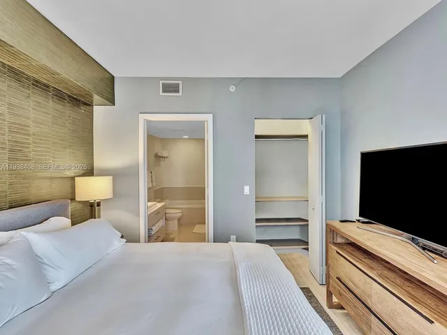 a bedroom with a bed and a flat screen tv