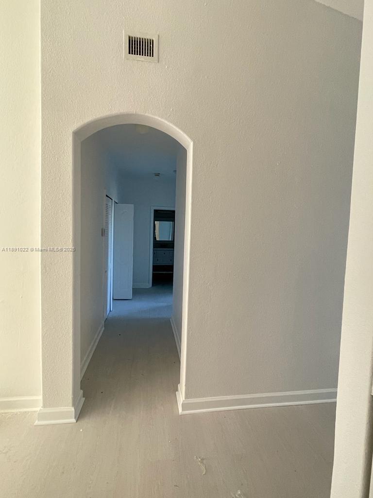 2903 Southeast 17th Avenue, Unit 206 Homestead, FL 33035 - Photo 11 of 28 a view of a hallway with wooden shelves