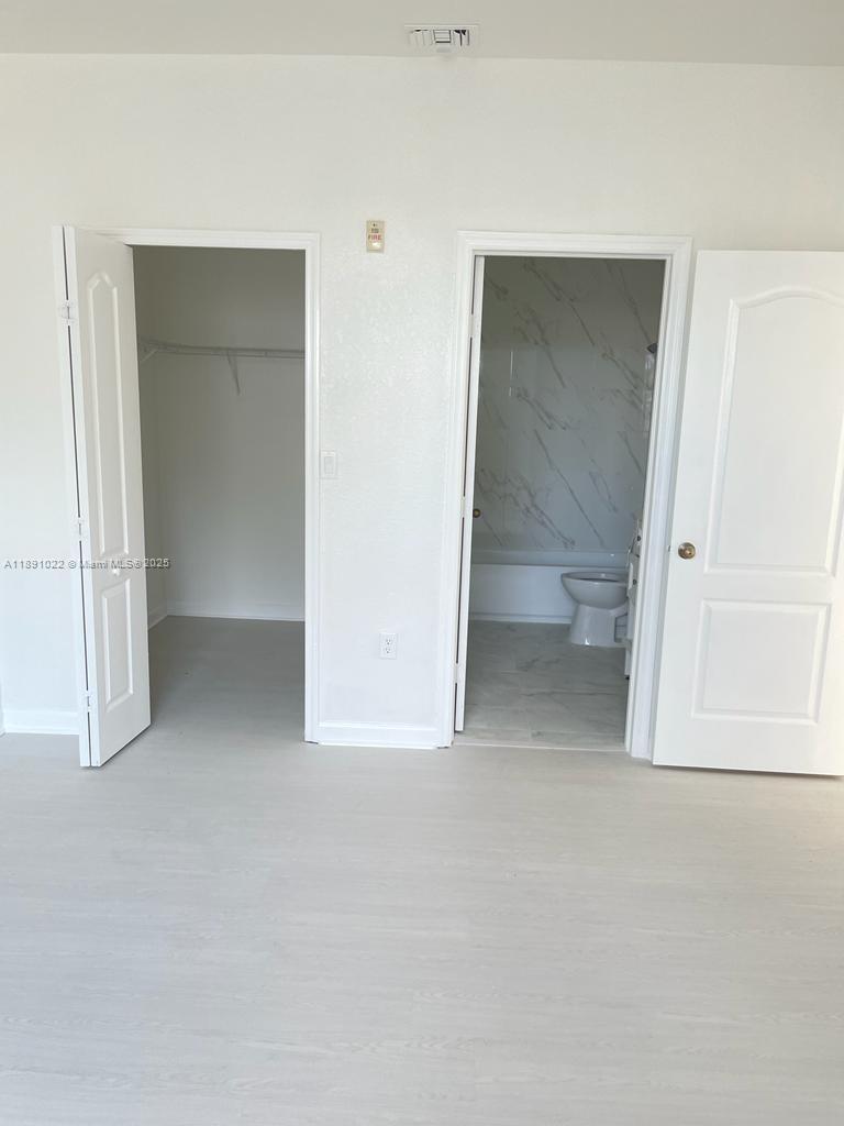 2903 Southeast 17th Avenue, Unit 206 Homestead, FL 33035 - Photo 13 of 28 an empty room with a bench and cabinet