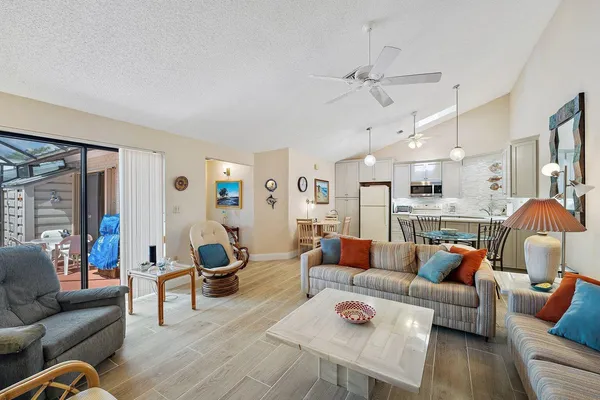 a kitchen with a dining table chairs refrigerator and microwave