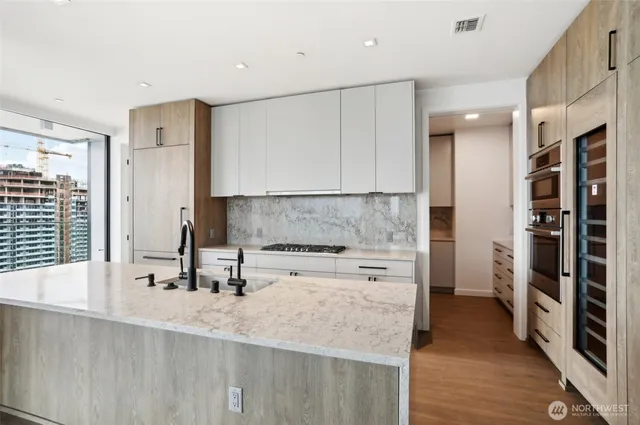 a kitchen with stainless steel appliances granite countertop a sink a stove and a refrigerator