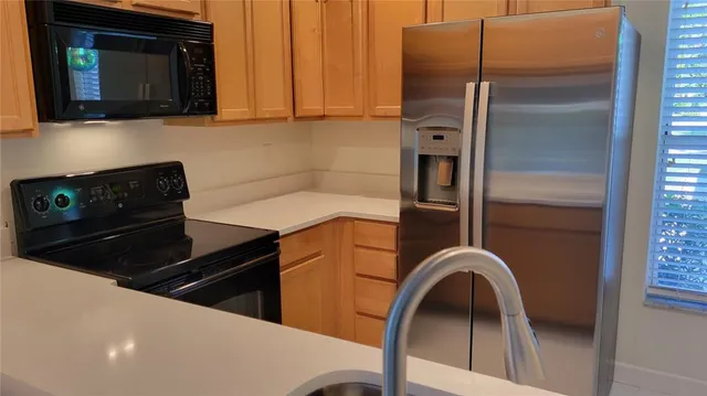 a kitchen with a refrigerator and a stove top oven