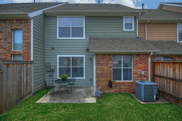 a view of a chair and table in backyard of the house