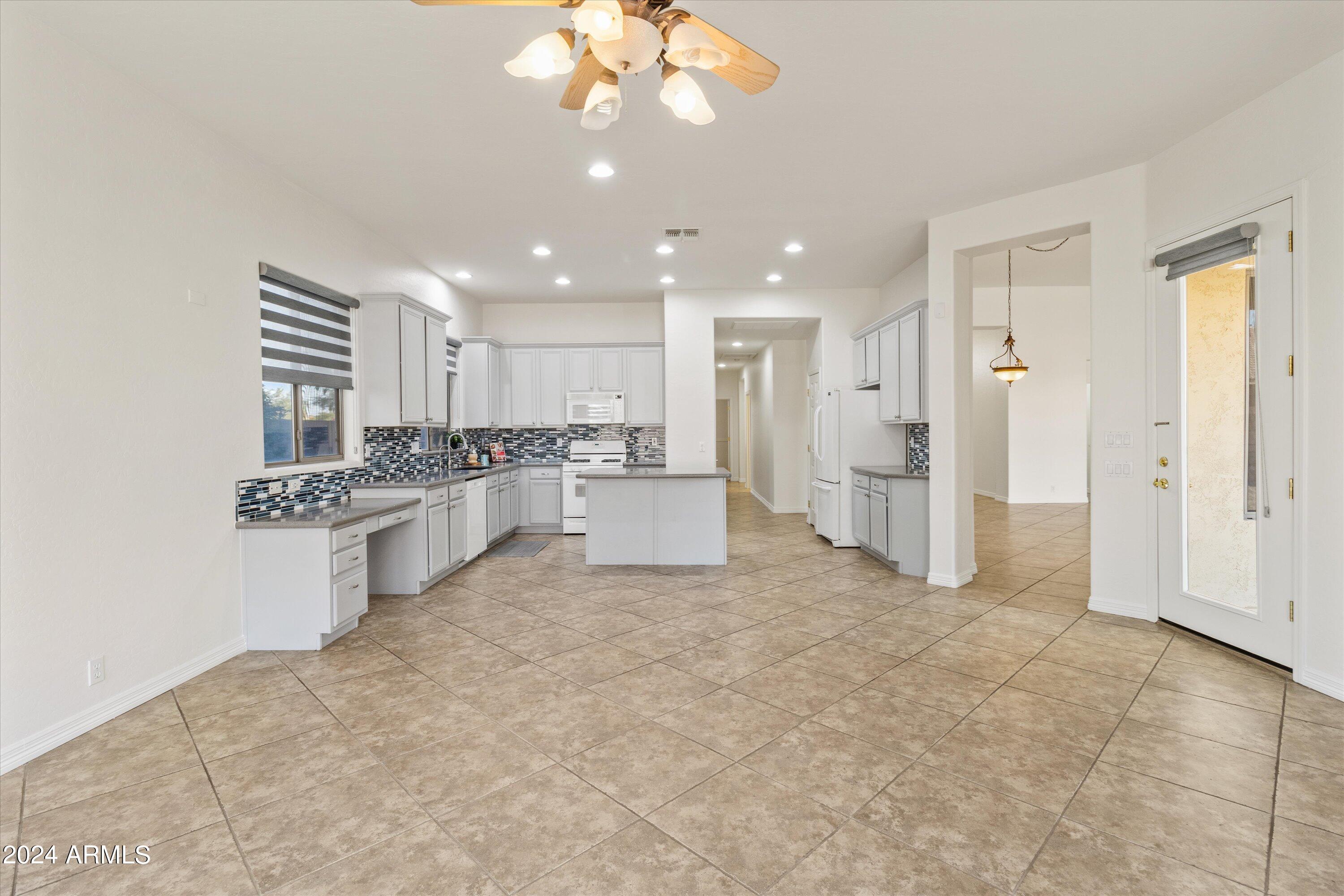 2860 East Nunneley Road Gilbert, AZ 85296 - Photo 11 of 28 a large white kitchen with a stove a sink and a refrigerator