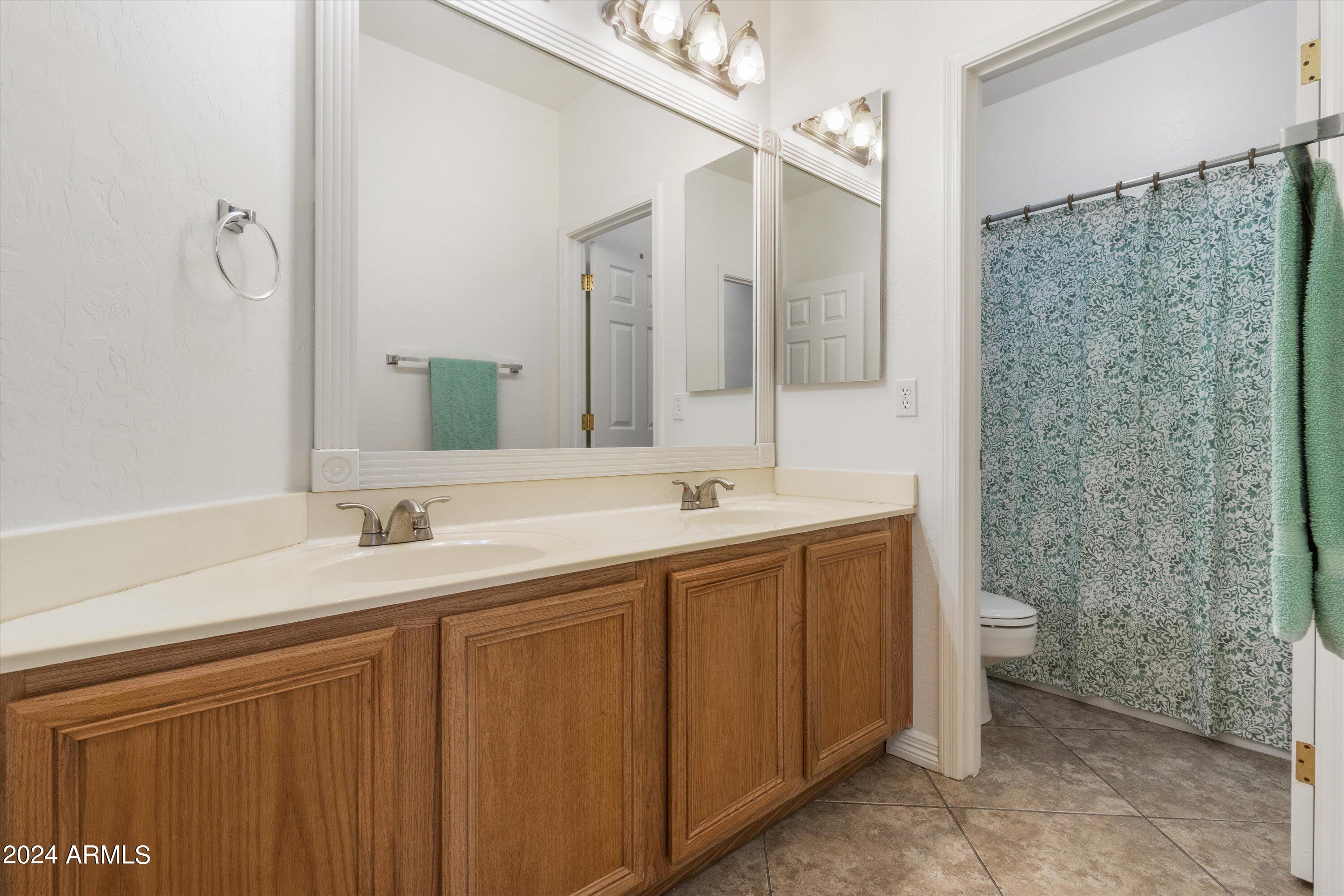 2860 East Nunneley Road Gilbert, AZ 85296 - Photo 18 of 28 a bathroom with a double vanity sink toilet and a mirror