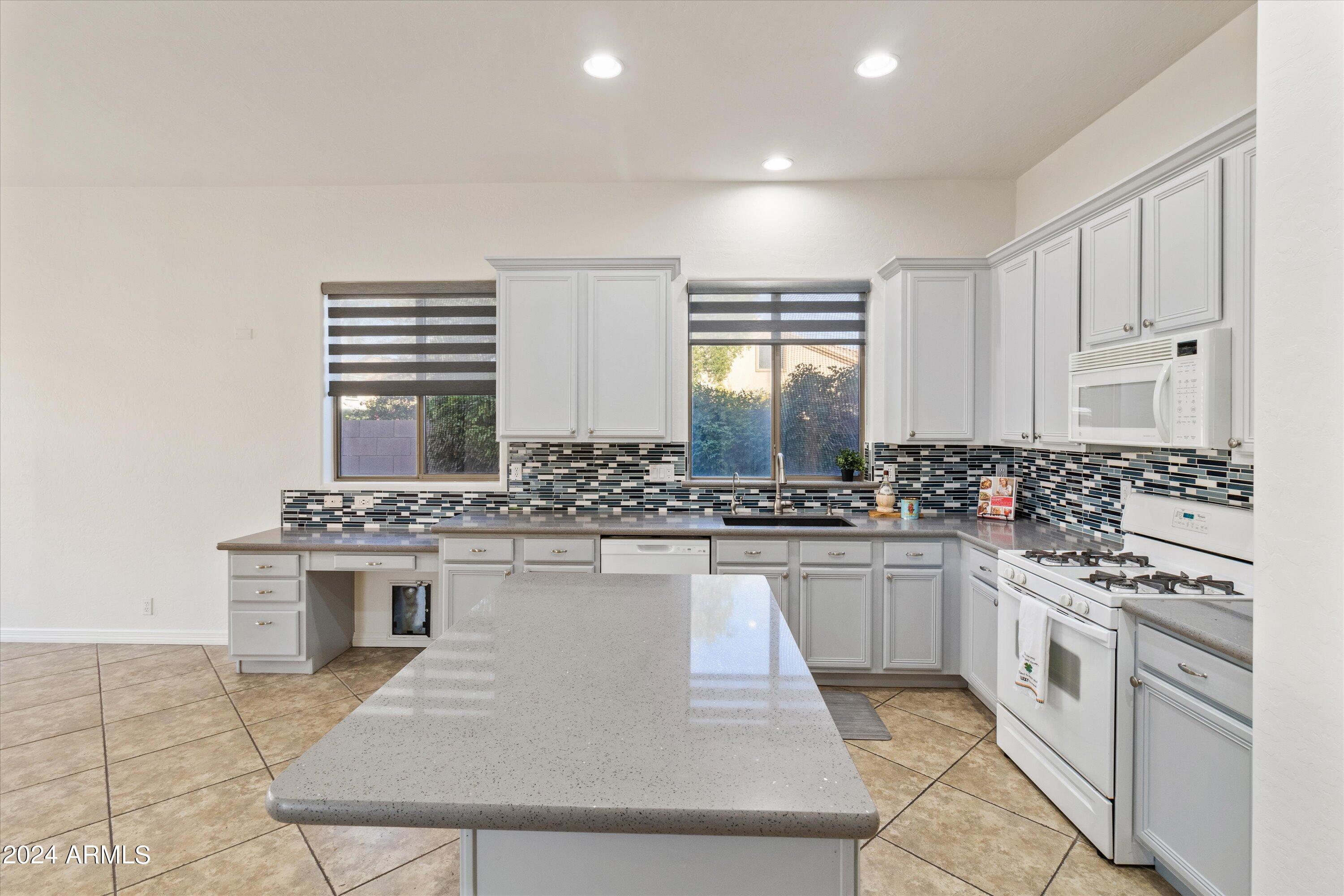 2860 East Nunneley Road Gilbert, AZ 85296 - Photo 2 of 28 a kitchen with a stove a sink and a refrigerator