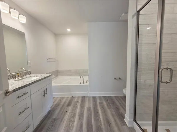a bathroom with a granite countertop bathtub shower sink and toilet