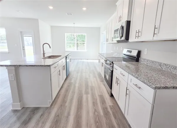a large white kitchen with sink and window