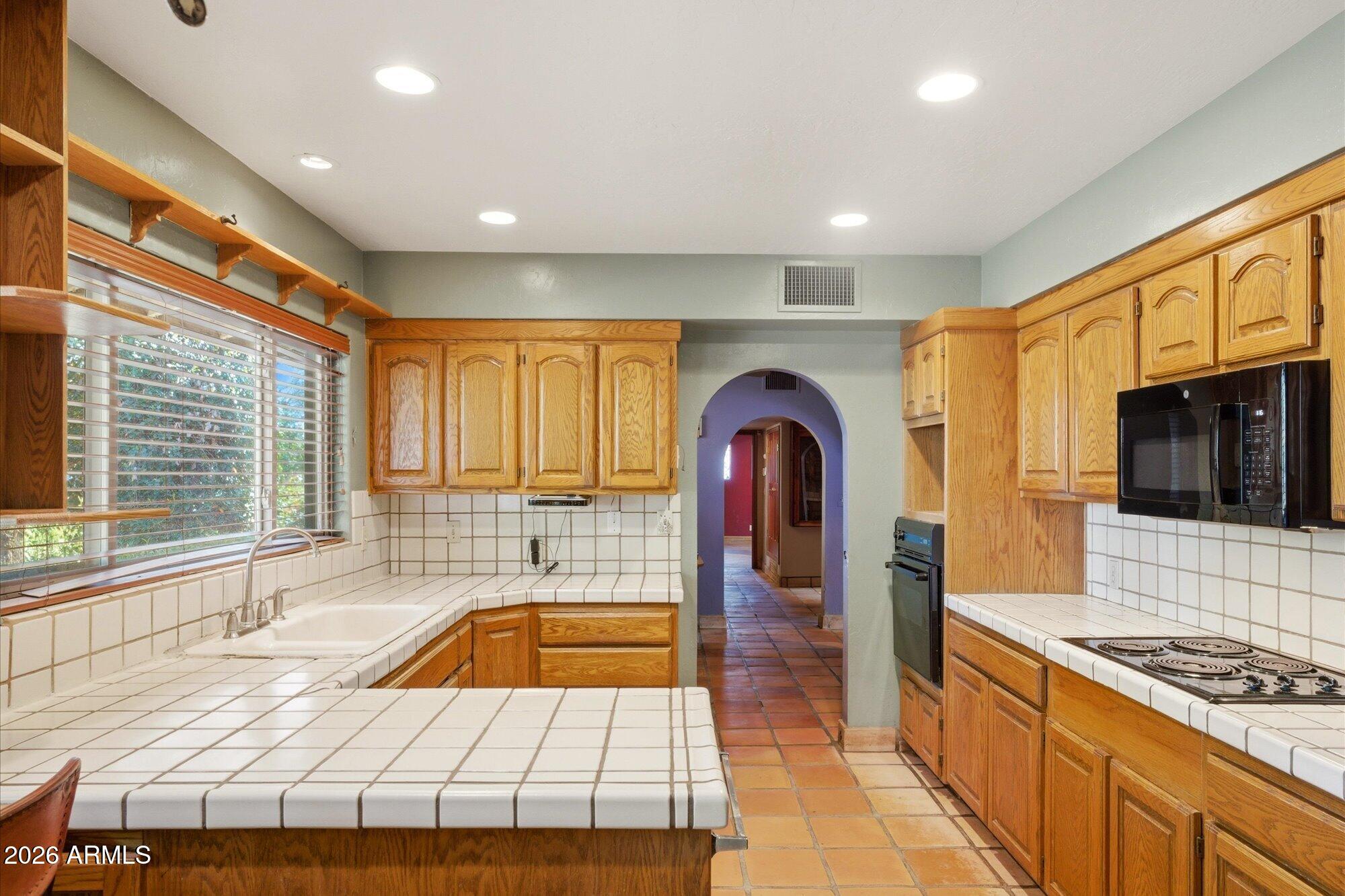 8324 North 8th Avenue Phoenix, AZ 85021 - Photo 9 of 39 a kitchen with stainless steel appliances granite countertop a sink a stove and a refrigerator