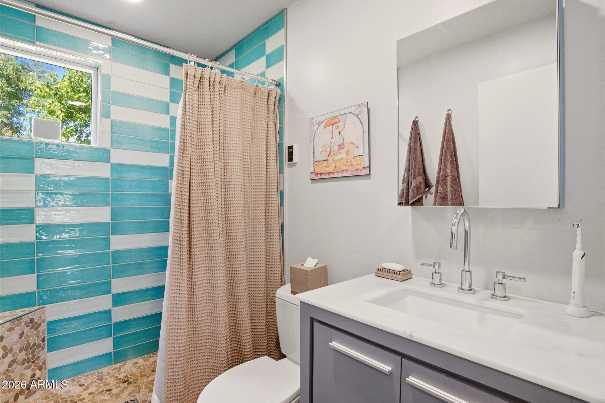 8324 North 8th Avenue Phoenix, AZ 85021 - Photo 23 of 39 a bathroom with a sink a toilet and shower curtain