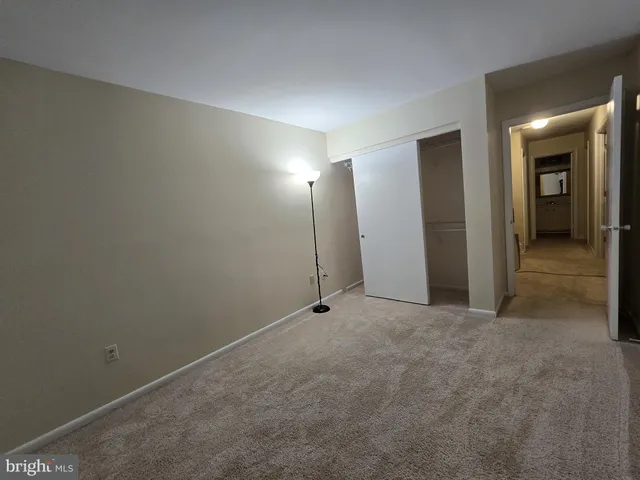 an empty room with closet and a bathroom