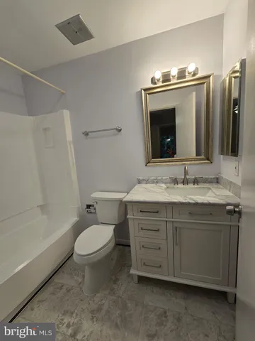 a view of an empty room with wooden floor fireplace and a window
