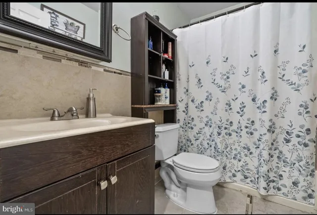 a bathroom with a granite countertop toilet and a sink