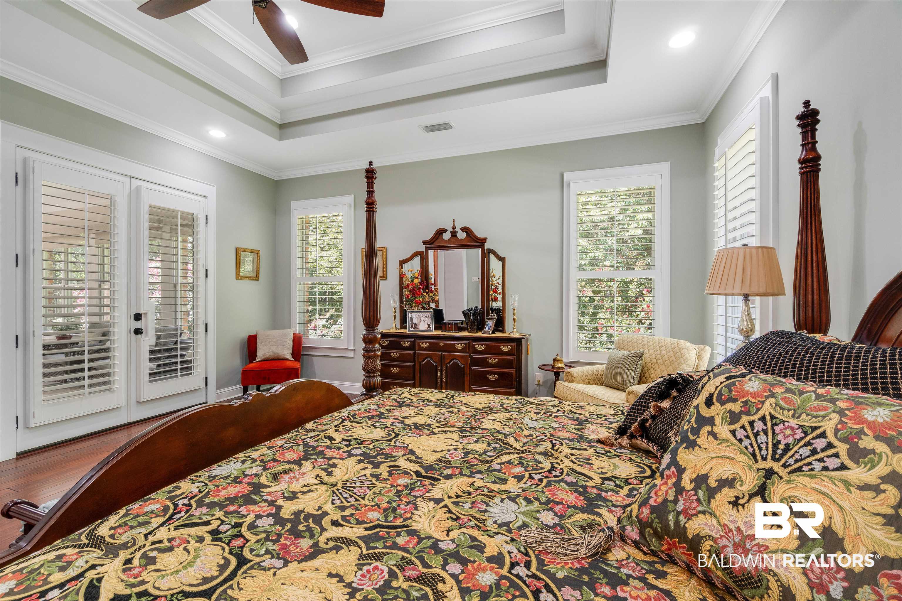 11281 Redfern Road Daphne, AL 36526 - Photo 26 of 80 Bedroom featuring a tray ceiling, crown molding, and hardwood / wood-style flooring