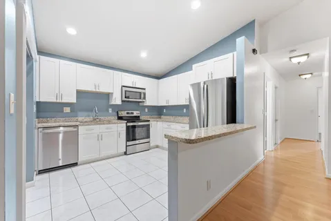 a kitchen with white cabinets and stainless steel appliances