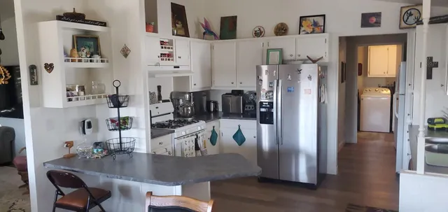 a kitchen with stainless steel appliances granite countertop a refrigerator and microwave