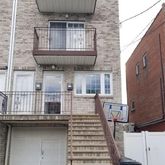 a front view of a house with barbeque grill and stairs