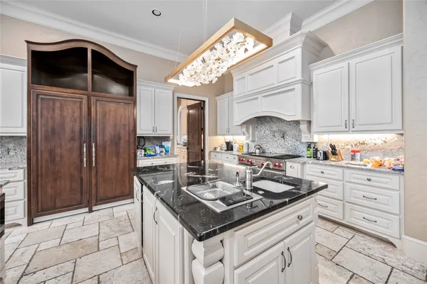 a kitchen with kitchen island granite countertop a sink and cabinets